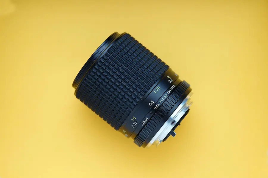 a DSLR lens on a yellow backdrop